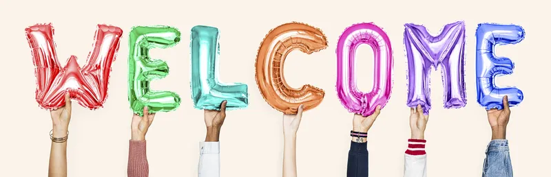 Diverse hands hold up multicolored letter balloons that say WELCOME