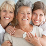 3 generations of women embrace: a mom, grandma, and daughter