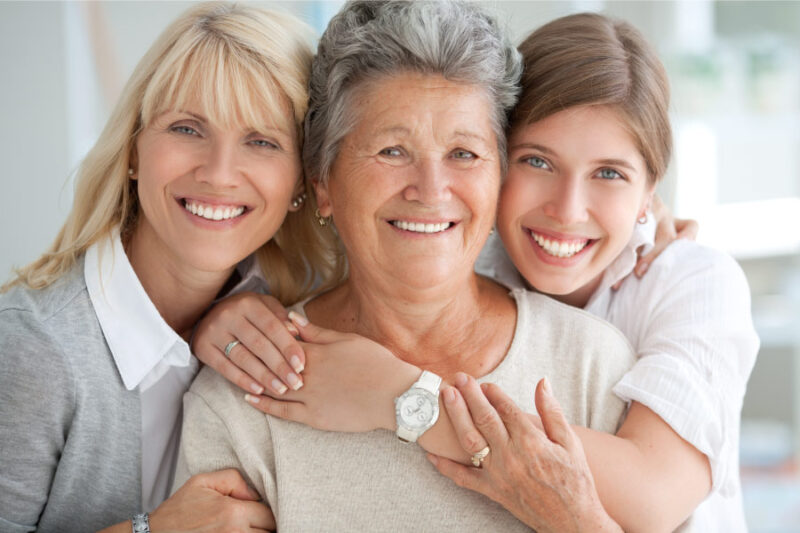 3 generations of women embrace: a mom, grandma, and daughter
