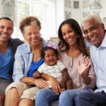 Grandparents next to their daughter, son-in-law, and granddaughter