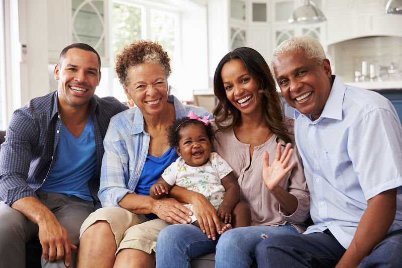 Grandparents next to their daughter, son-in-law, and granddaughter