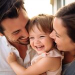 A mom and dad snuggle close to their smiling daughter