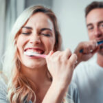 young couple brush their teeth together