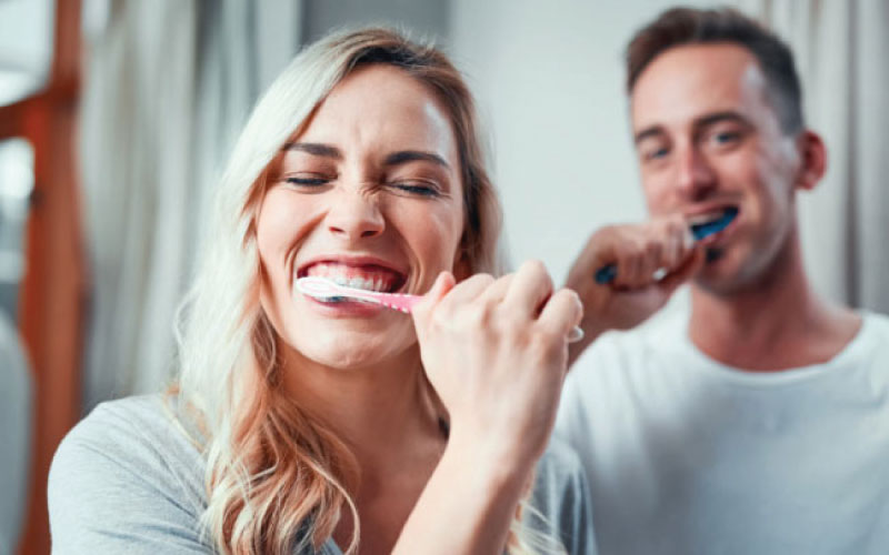 young couple brush their teeth together